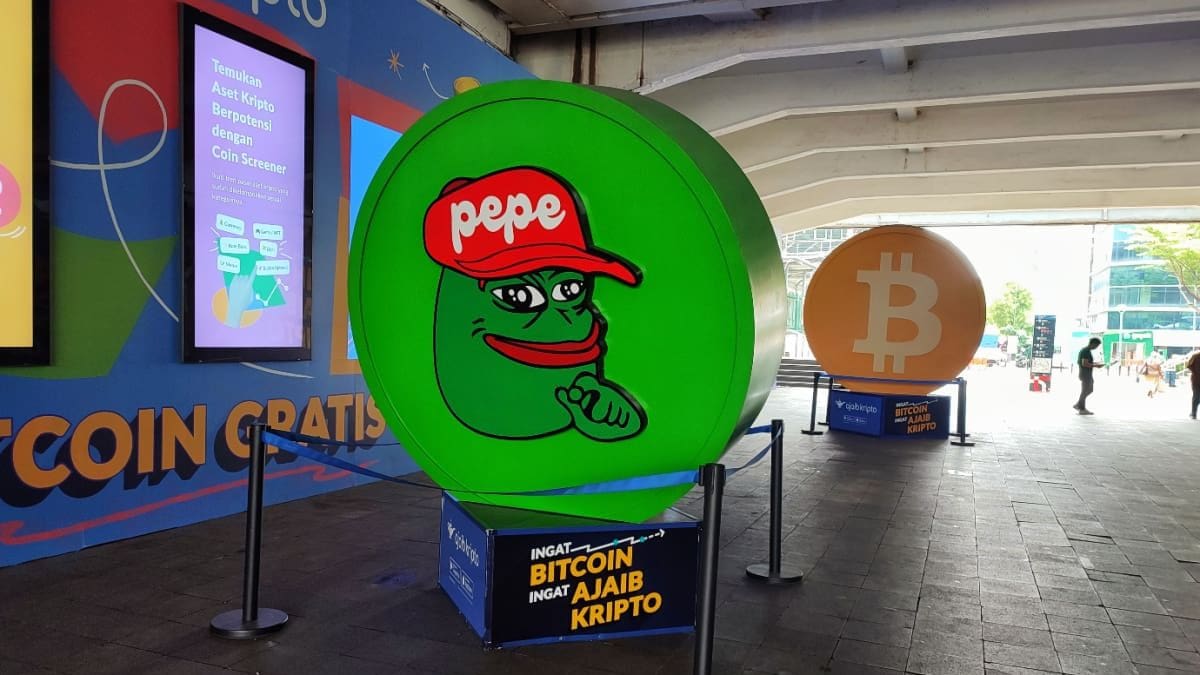 Bitcoin op de rem, maar memecoins schieten om deze reden omhoog Een fysieke afbeelding van pepe coin (PEPE), een van de grootste memecoins van de cryptomarkt, op een crypto conferentie