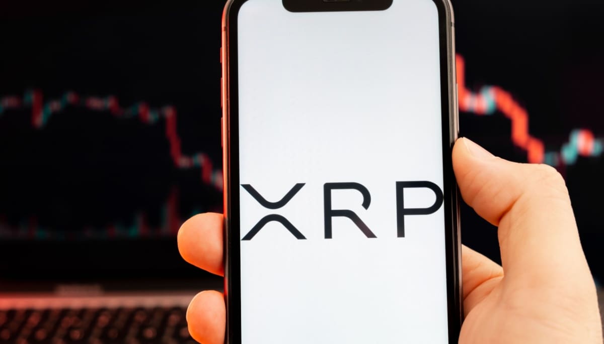 XRP logo op mobiel met koersgrafiek XRP logo op mobiel met koersgrafiek