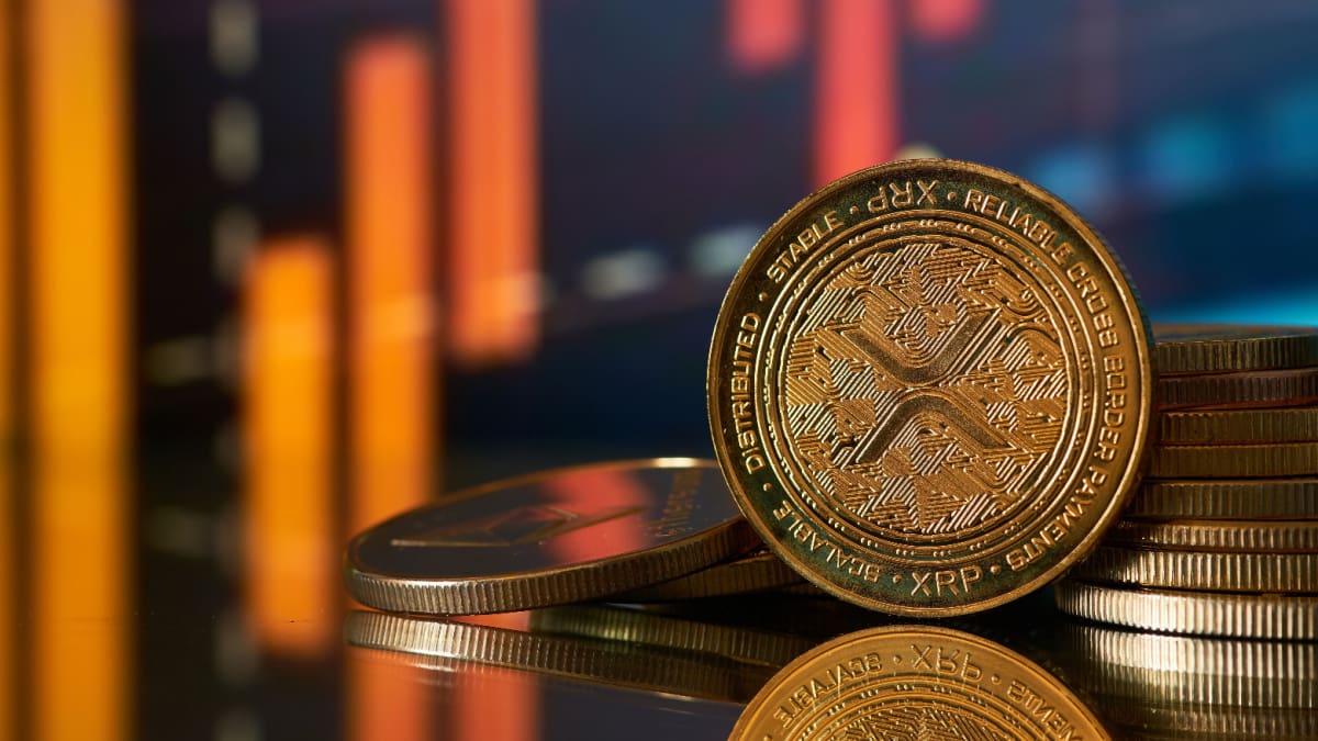 Een afbeelding van een XRP munt, een project van Ripple met op de achtergrond een rode, dalende koers