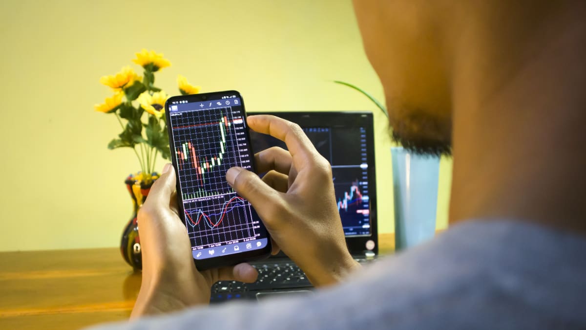 Terwijl alle crypto instort, schiet één onbekende munt plots 87% omhoog Een afbeelding van een stijgende crypto koers op een mobiele telefoon die door een amateur handelaar wordt vastgehouden