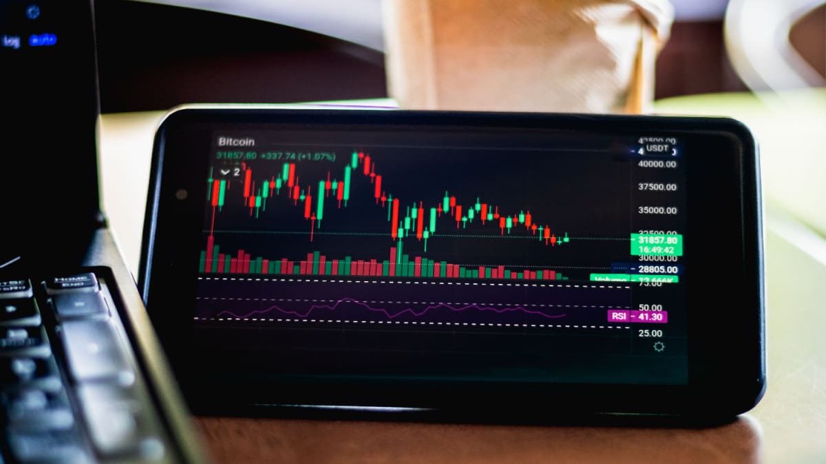 Een afbeelding van de bitcoin koers op een mobiele telefoon met daarbij horende technische data