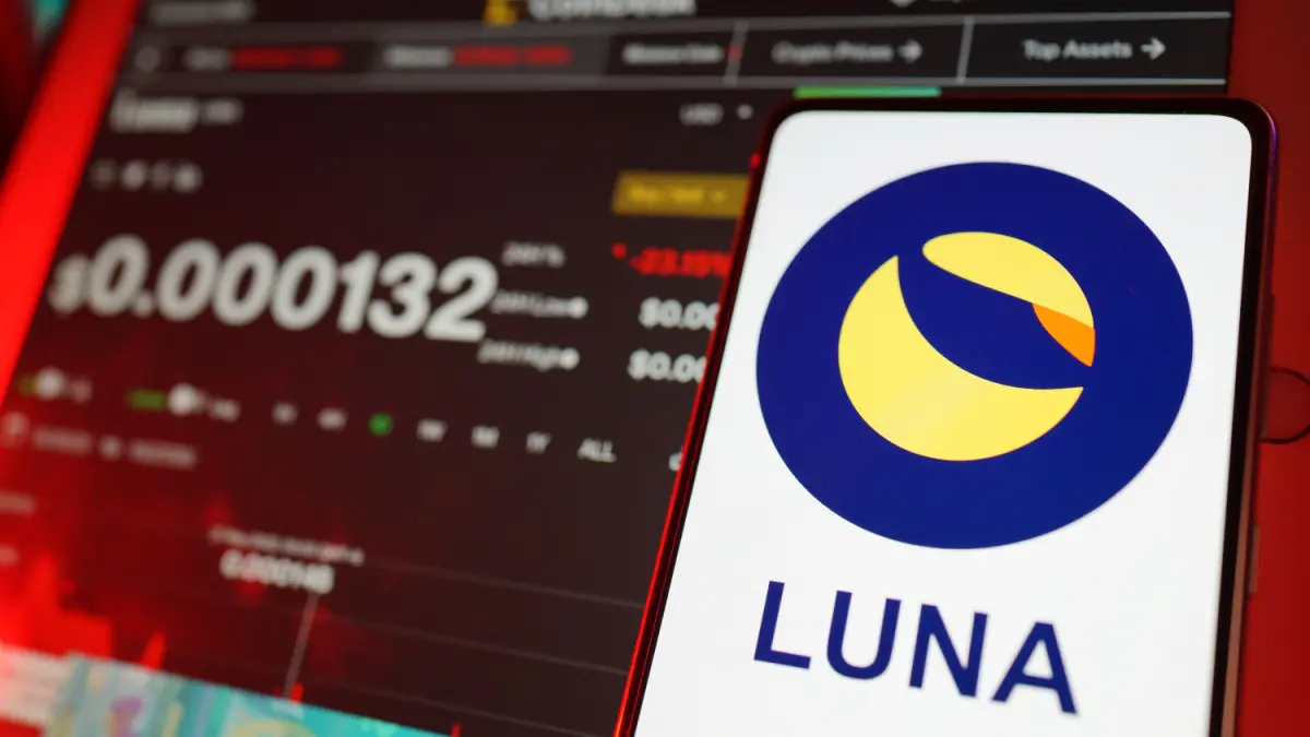 Nasleep Terra-drama: Handelsbedrijf aangeklaagd voor $4 miljard na crash Een afbeelding van het logo van Terra (Luna) met op de achtergrond een koers en een grafiek op een coinpagina van de munt