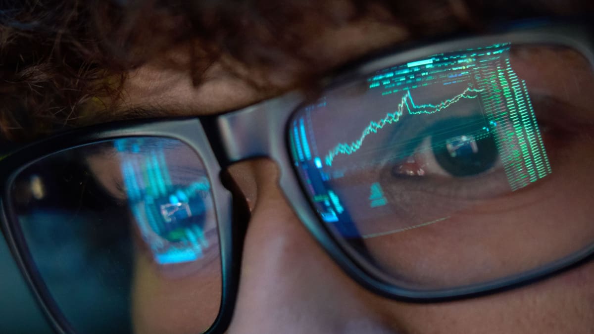 Een afbeelding van een jonge crypto investeerder die naar scherm kijkt meet een stijgende grafiek