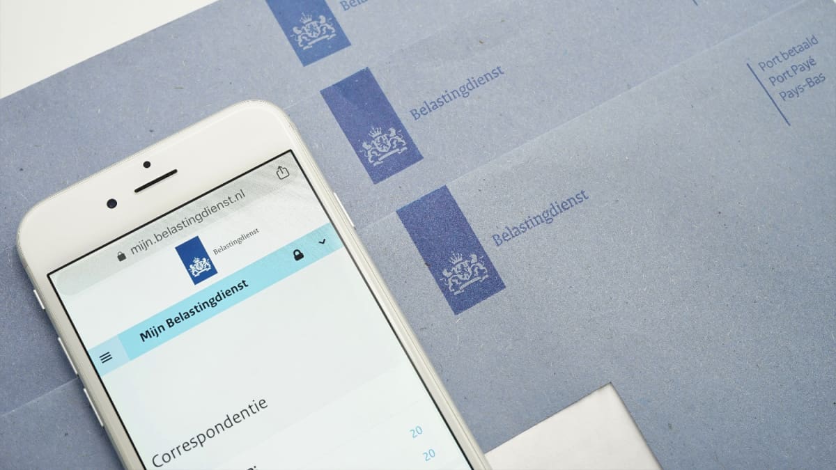Een afbeelding van 'Mijn belastingdienst' op de Nederlandse overheidssite met blauwe brieven op de achtergrond