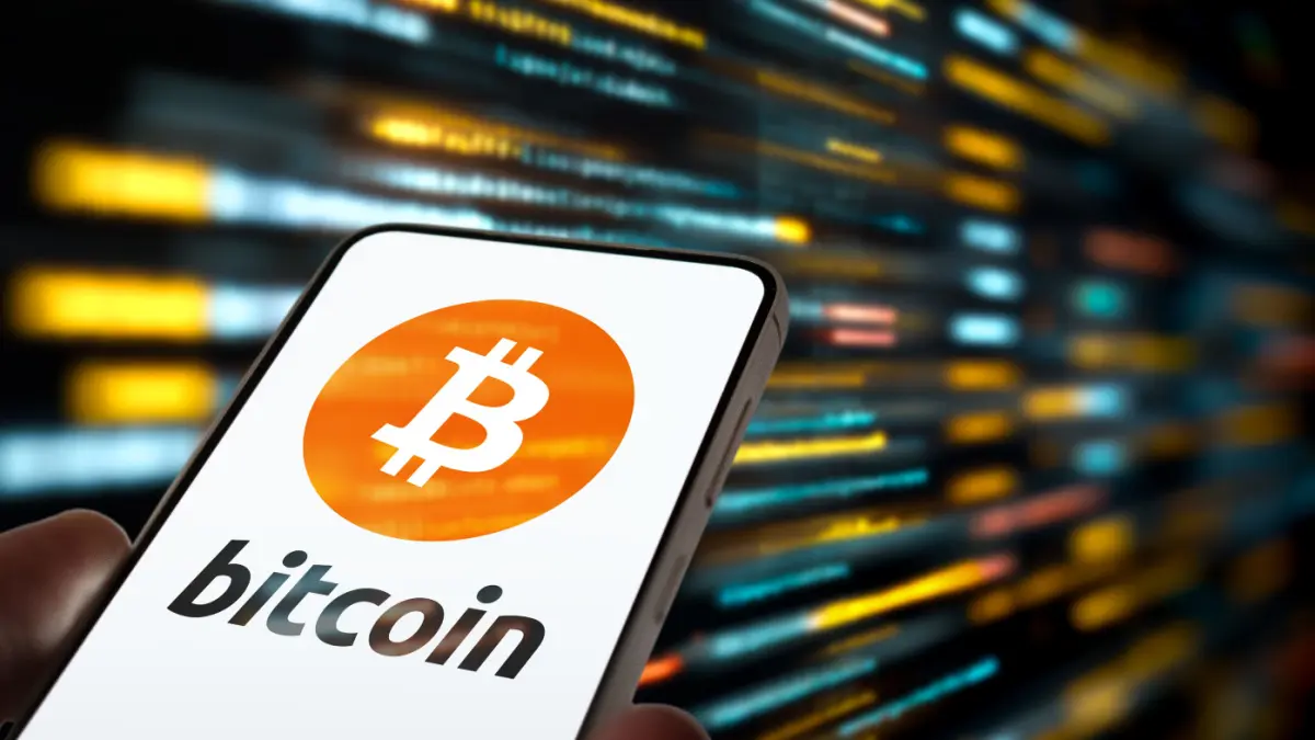 Een afbeelding van het bitcoin (BTC) logo op een mobiele telefoon Een afbeelding van het bitcoin (BTC) logo op een mobiele telefoon