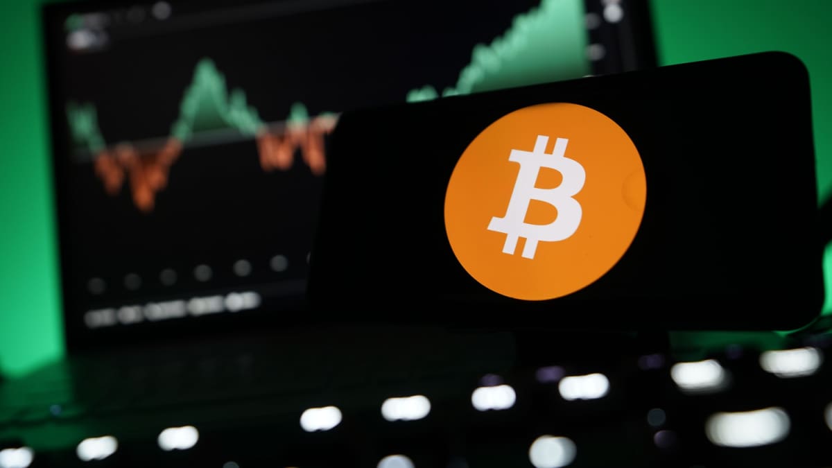 Een afbeelding van het bitcoin logo met een stijgende koers op de achtergrond