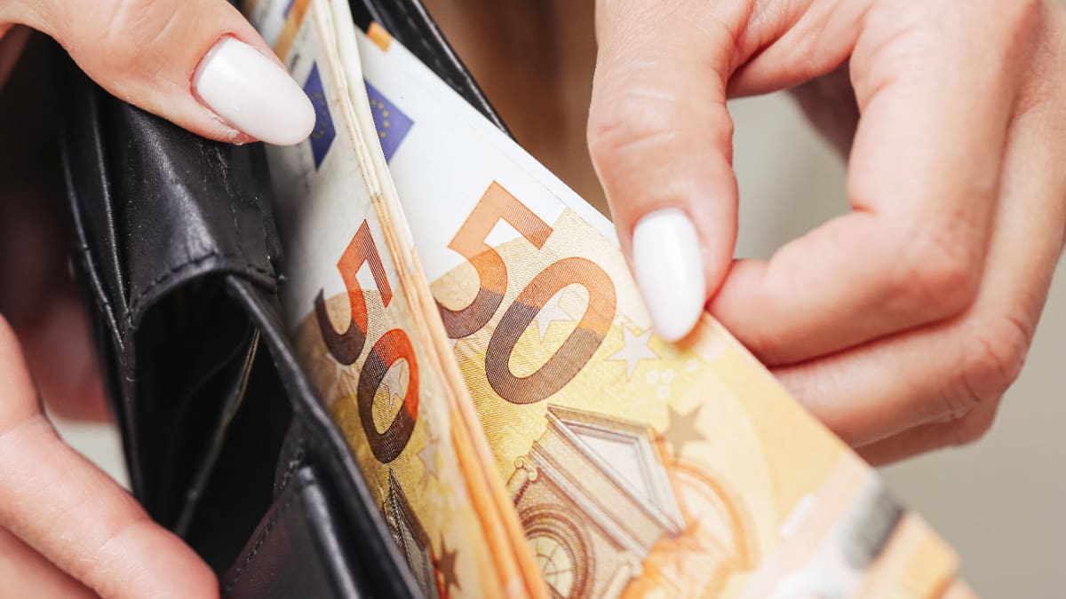 Spanje domineert markt voor digitale euro, Nederland op vierde plek Een afbeelding van vrouwelijke handen die briefjes van 50 euro uit een portemonnee trekken